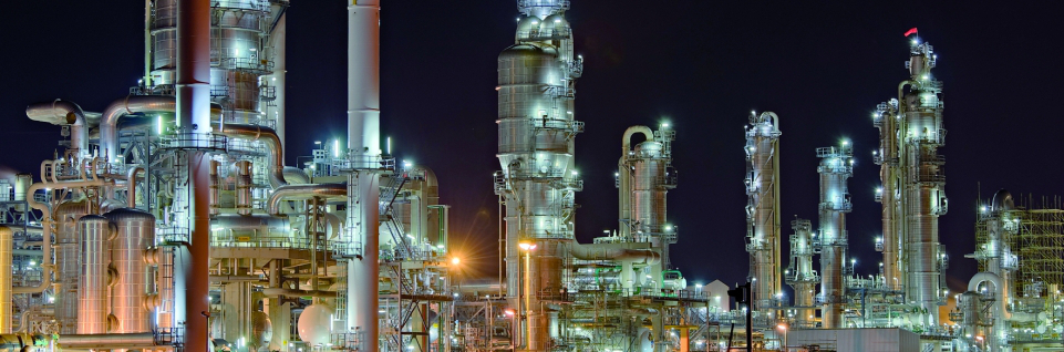 oil & gas machinery lighted up against the night sky