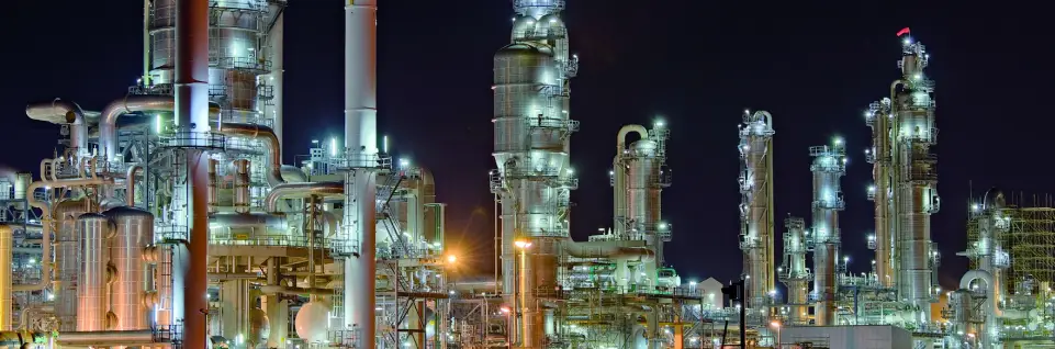 oil & gas machinery lighted up against the night sky