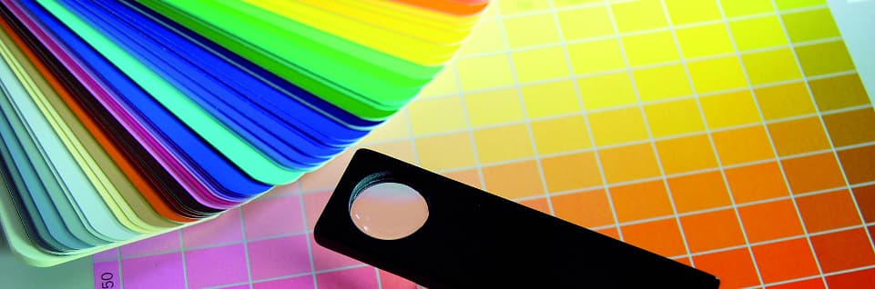 colour cards of different colours stacked and spread over yellow orange pink gradients