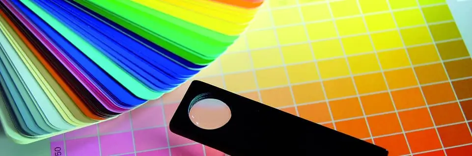colour cards of different colours stacked and spread over yellow orange pink gradients