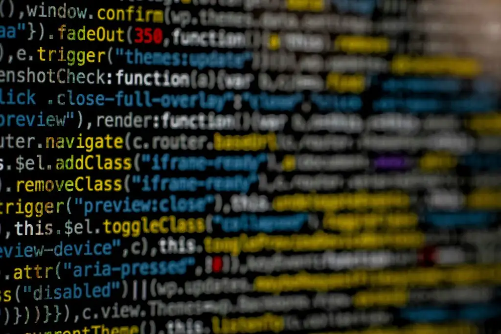 image with software coding on screen with dark mode and half of the image blurred out